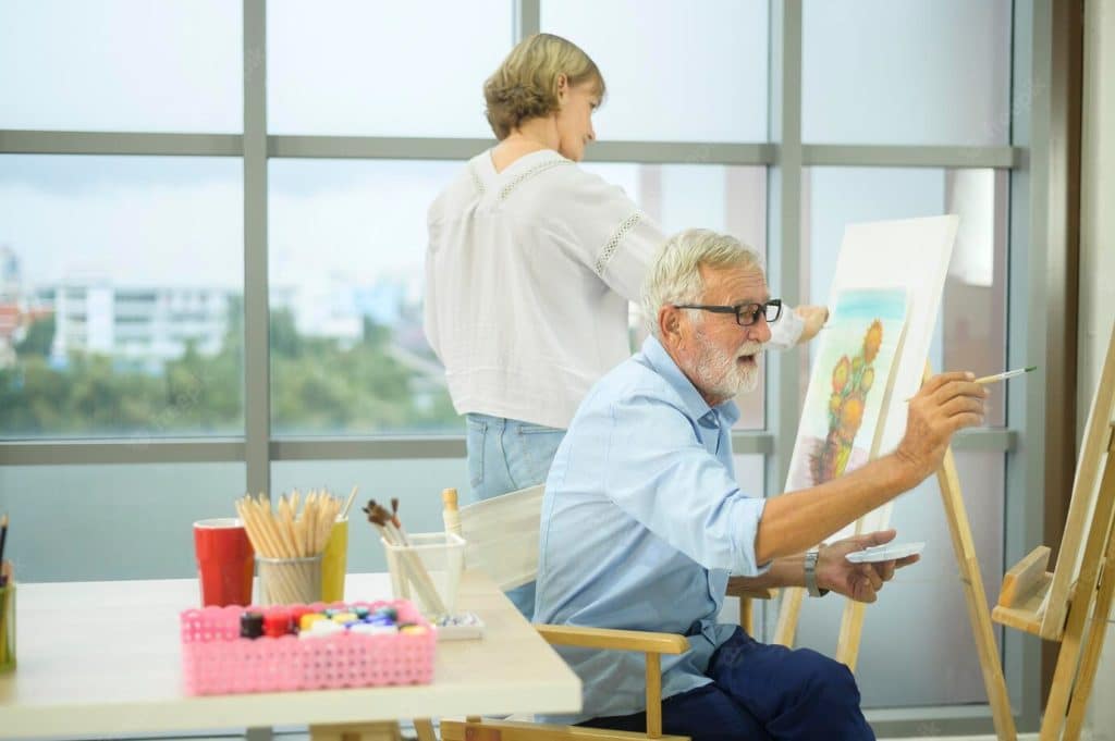 Dos personas mayores pintando en un taller