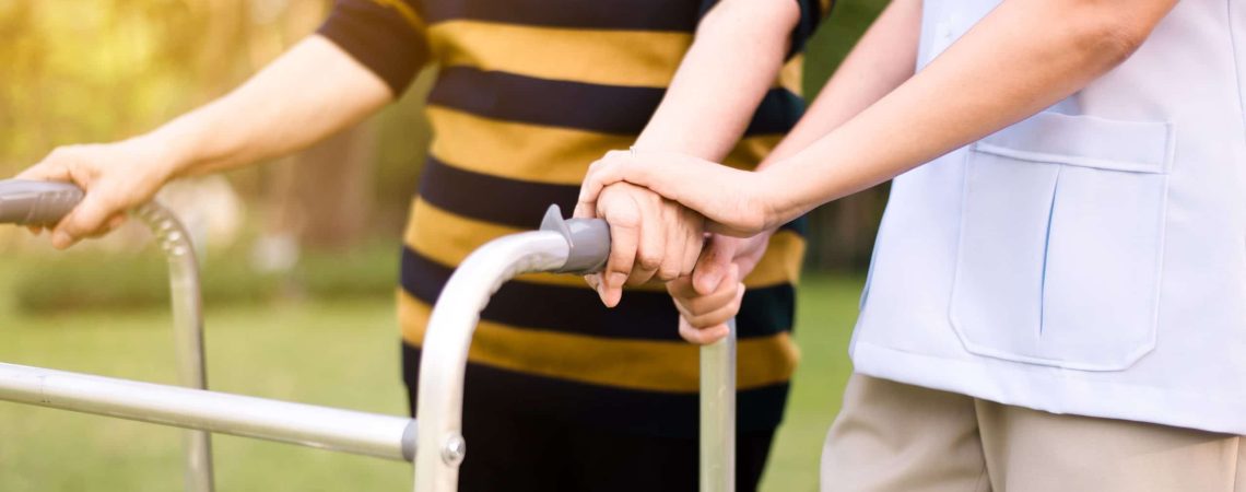 Cuidadora ayudando a una persona mayor en su rehabilitación física