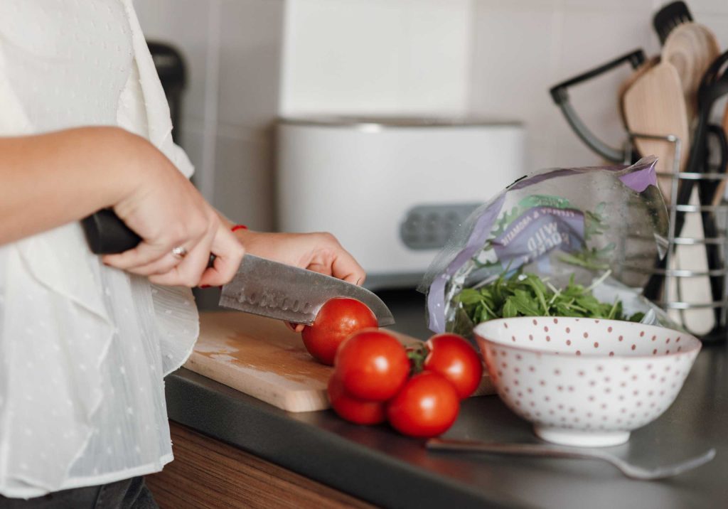 mujer cortando tomates