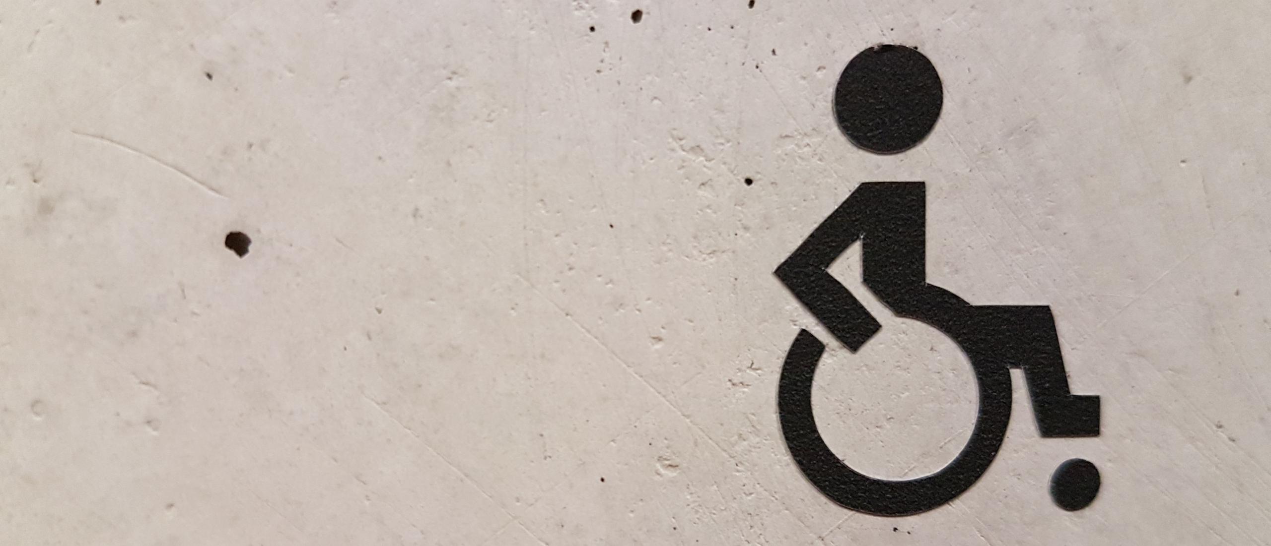 Dibujo icono persona en silla de ruedas en un muro
